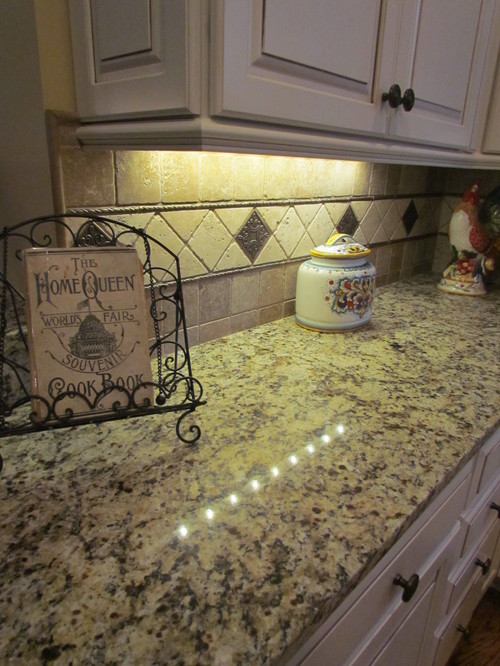 Giallo Napoli with Cocoa Glazed Canvas Maple Cabinets, Tumbled Travertine 4x4 Square Backsplash and Bronze Accent and Liner